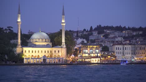 Mosque-and-crowd-of-people-at-night-on-the-seashore.